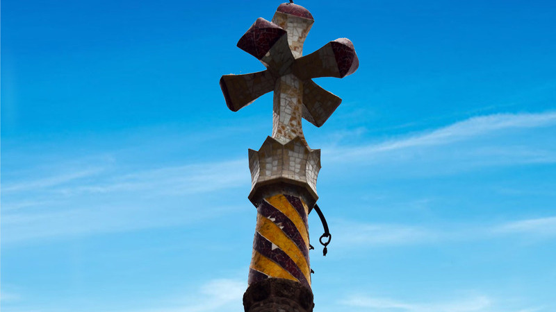 *Cruz de cuatro brazos de Gaudí, inspirada en el gálbulo del ciprés*